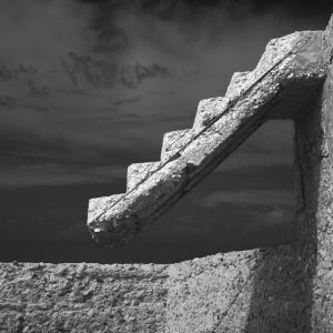 Crumbling concrete steps with clouds as background