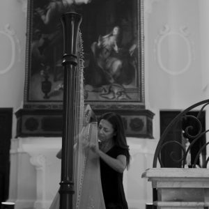 Harpist Giuseppina Ciarla performing under the Annunciation painting in the church of Montorio nei Frentani, Italy