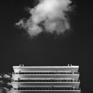 A cloud above a white apartment building