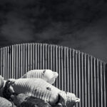 A heap of buoys lying by a corrugated metal shed.