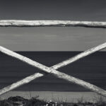 Wooden fence with crossed bars against sea.