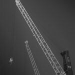 Two harbour cranes with white arms extended diagonally.
