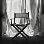 Foldable canvas chair with white curtain as backdrop