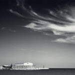 Fishing boat on harbour dock under swirling clouds.