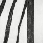Dark L-shaped and diagonal wood in white timber frame wall